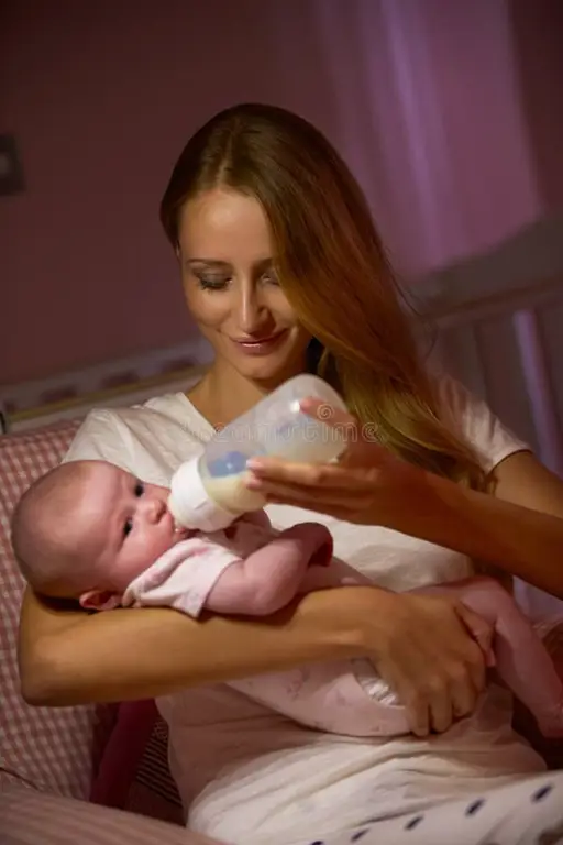 Ibu memberi makan bayi dengan botol susu