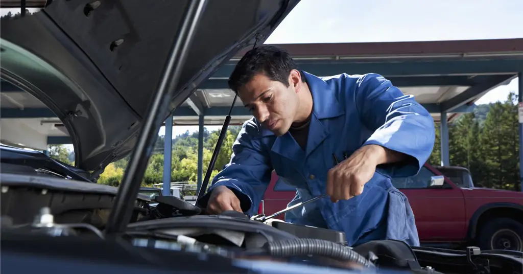 Mekanik sedang memperbaiki mobil