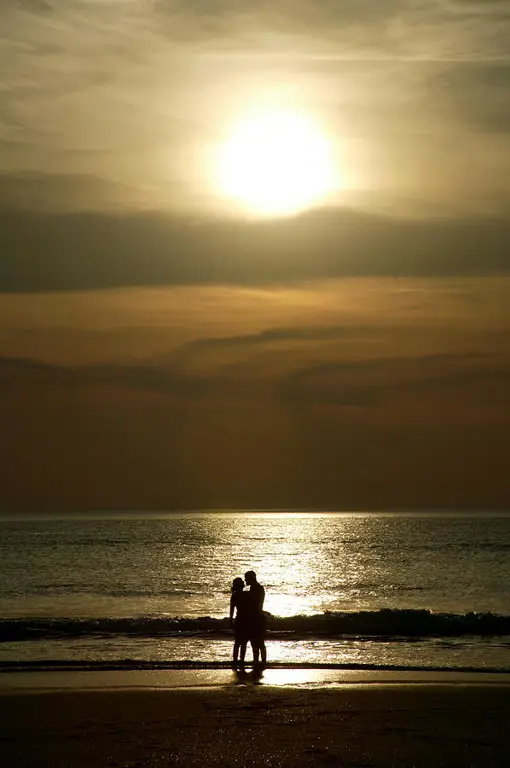 Pasangan di pantai saat matahari terbenam