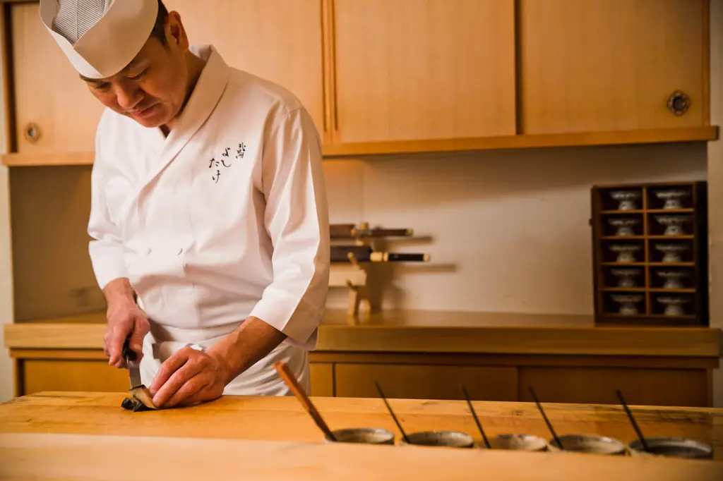 Chef Jepang sedang menyiapkan makanan dengan saus Yoshitake