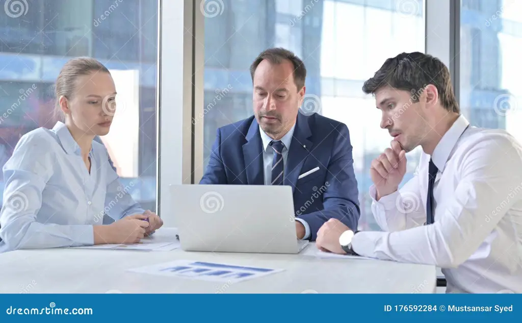 Gambar seseorang bekerja di laptop di kantor