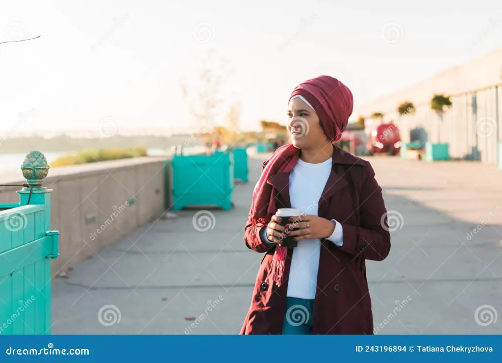 Gambar wanita berhijab dari belakang sedang berjalan di jalan yang sunyi