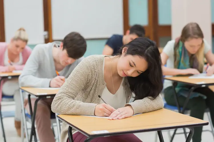 Seorang siswa SMP sedang mengikuti ujian sekolah dengan serius