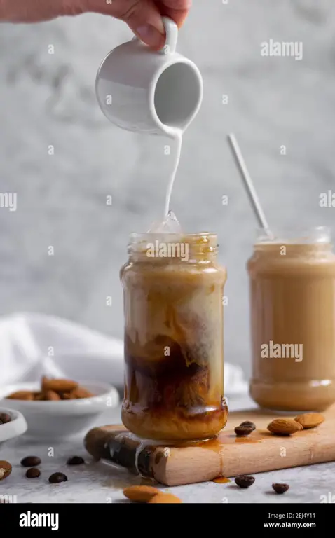 Menuangkan susu almond ke dalam gelas