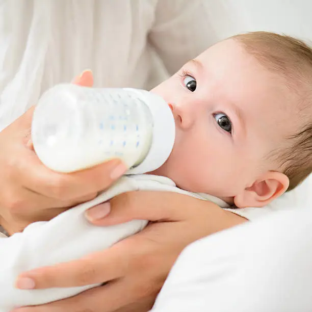 Bayi sehat dan bahagia sedang minum susu