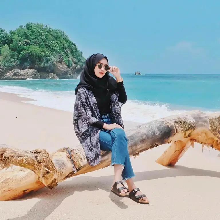 Remaja hijabers dengan outfit kasual di pantai