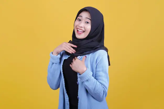 Wanita tersenyum sambil mengenakan hijab jersey