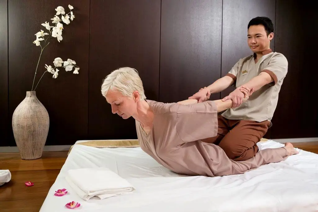 Gambar seorang terapis shiatsu sedang memijat kliennya.